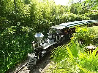 Een trein van de Plopsa Express gezien vanuit de wachtrij van DinoSplash.