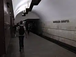De metro naar het oosten onder de trappen naar Rimskaja en de stationsnaam op de tunnelwand.