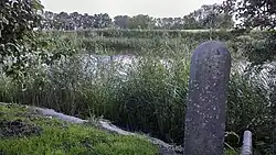 Groningse grenspaal aan de oever van de Lauwers