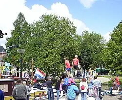 Fierljeppen. Aan de overzijde het park