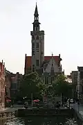 Gezicht van over de Spiegelrei op het Jan van Eyckplein en de Poortersloge. Uit de opening linksonder in de kaaimuur loopt de overwelfde Kraanrei in de Spiegelrei.