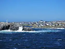 Zicht op het dorp met links de vuurtoren van Channel Head