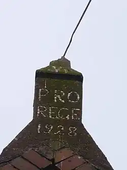 Nok van de voormalige dependance van de kerk van Surhuizum in 2018. De tekst van het opschrift luidt: PRO REGE 1928