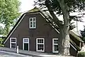 Hoeve met strodak en in de voorgevel oude kozijnen, luiken en oorspronkelijke roedenverdeling