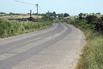 De R750 als betonnen weg zonder wegmarkeringen ten zuiden van Brittas Bay