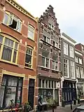 Pand met renaissance trapgevel met geblokte jonische pilasters, vlechtwerk boven de vensters en sierankers