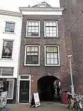 Pand met lijstgevel voor een huis, dat de poort bevat, die vanuit de voorstraat toegang geeft tot het hof