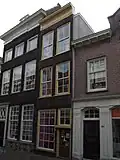 Pand met smalle gevel met verkropte kroonlijst met in de verdiepingen schuiframen