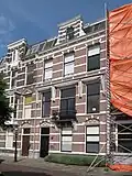 Herenhuis in neorenaissance trant, met natuurstenen banden, vensterstrekken met blokken en in de verdieping boven de vensters hoofdgestellen op consoles. Balkon op ijzeren hekje op consoles. Kroonlijst met consoles en daarboven stenen dakkapel met voluten