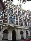 Pand met renaissancegevel. Zeer rijke gevelbehandeling met banden, halve zuilen en pilasters met bewerkte schachten, sluitstenen, lijsten en consoles. Topgevel met voluten en bekronend gebroken fronton. Getoogde parterrevensters. Links een erker op consoles