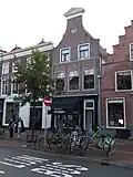 Pand met klokgevel met driehoekige frontonbekroning, beneden verbouwd