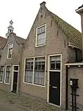 Huis achter puntgevel met vlechtingen en oude kozijnen