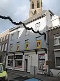 Gepleisterd huis met aan de Grotekerkstraat een achtzijdige toren met tandlijsten en boogfries