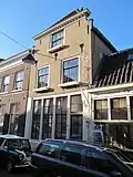 Pand met afgeknotte trapgevel. Het huis draagt een schilddak, dat achter aansluit tegen een puntgevel. In de voorgevel ontlastingsbogen en drie sierankers. Onderpui omstreeks 1800