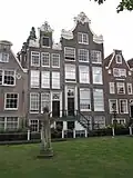 Zeer gaaf huis met rijke ingezwenkte halsgevel van het type met 'Gebogen pilasters'