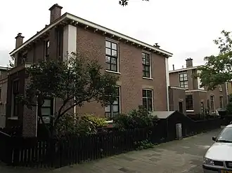 Blok van vier rug-aan-rug gebouwde woningen op vierkante plattegrond, bestaande uit begane grond en verdieping onder een plat dak