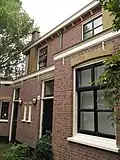 Blok van vier rug-aan-rug gebouwde woningen op vierkante plattegrond, bestaande uit begane grond en verdieping onder een plat dak