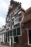 Huis met trapgevel met hardstenen banden en blokken in bogen boven de ramen. Deels pakhuis