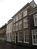 Huis met ontpleisterde lijstgevel, en met pilasters en kroonlijst versierde ingang