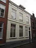 Huis met gebosseerd witgepleisterde lijstgevel