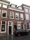 Huis met eenvoudige empire lijstgevel in schoon werk met ingangsomlijsting en bovenlicht met segmentmotieven