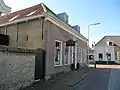 Woonhuis van beganegrond met omlopend schilddak. Gedateerd in een gevelsteen