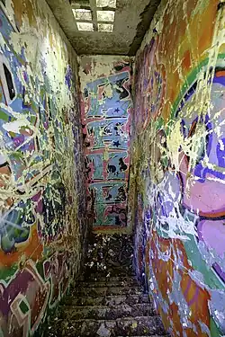 Toegangstrap naar de ingang van de bunker. In het plafond de typische raatbouwelementen uit de jaren 1950