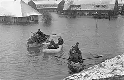 Bewoners van het overstroomde Tuindorp Oostzaan worden met roeiboten geëvacueerd; 14 januari 1960.