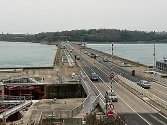 Weg over de dam met de schutsluis op de voorgrond