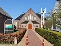 Kerk. Regenboogkerk, vh Rehobothkerk. Sober vormgegeven kerk uit 1923. Wijzigingen uit 1951 waarbij er 2 zijbeuken zijn bijgebouwd waardoor het een kruiskerk is geworden
