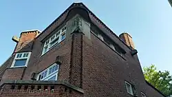 huisnummer 72: twee beeldhouwwerken Vrouw met kameleon op de arm en vrouw met kind; kunstenaar onbekend