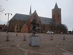 Beeld "Rennend Naakt Met Hinde", met kerk.