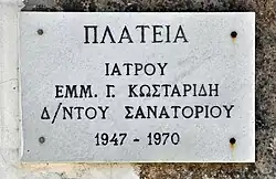 Gedenksteen voor de longarts Emmanuel G. Kostaridis, bij de trap naar de kerk