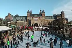 Schaatsen op de bevroren vijver met op de achtergrond het Rijksmuseum