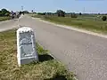 De grenspaal Angeren-Doornenburg naast de weg op de Rijndijk