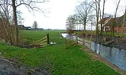 Beide boerderijen aan de Fraamweg. De wierde gaat deels schuil achter de bomen links