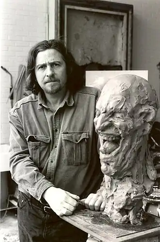 Roland Rens in zijn atelier met "De Lach" in klei