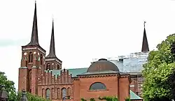 Links twee gebogen ingesnoerde torenspitsen op de torens van de Kathedraal van Roskilde.