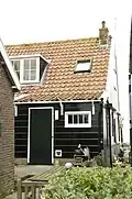 Perceelsgedeelte van een grotendeels houten huis
