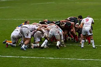 De XV van LOU (in het wit) in een scrum tegen Stade Toulousain (zwart)