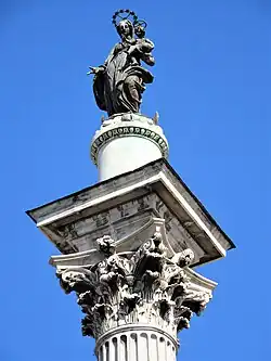 Zuil met het beeld van Maria op het voorplein van de basiliek.