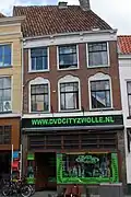Winkel met bovenwoning met lijstgevel en jongere winkelpui in de stijl van de Amsterdamse School