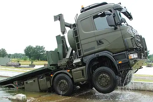 Een Scania WLS op het OTCRij beladen met een lege flatrack. De Scania WLS is voorzien van olijfgroene kleur zoals ook gebruikt bij het Commando Zeestrijdkrachten.