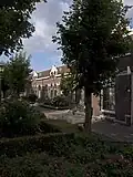 Complex arbeiderswoningen met bijbehorende tuinmuurtjes met hekwerken