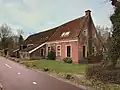 Boerderij met woonhuis met puntgevel en stal met zijbaander