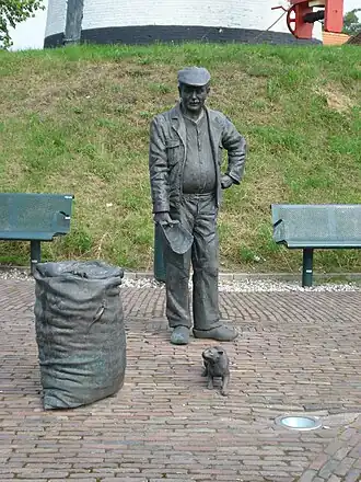 Sculptuur van molenaar voor de molen, een beeldhouwwerk van Toon Grassens 1994.