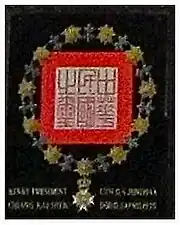 Wapenbord van Chiang als Ridder in de Serafijnenorde in de Riddarholmskyrkan in Stockholm. Het gaat hier niet om een wapen zoals in de Europese heraldiek maar om een kunstig gekalligrafeerd zegel met de keten van de orde.