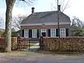 Dorpswoning met koetshuis en hek