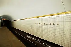 De stationsnaam op de tunnelwand bij het perron