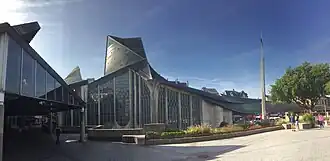 Buitenaanzicht op muur met glas-in-loodramen Sint-Jeanne d'Arc-kerk